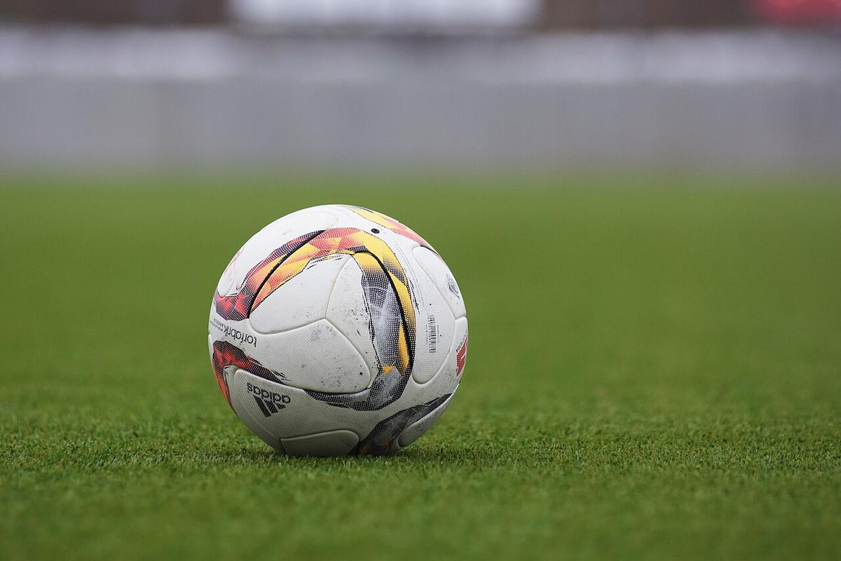 Un balón de fútbol sobre el césped de un estadio