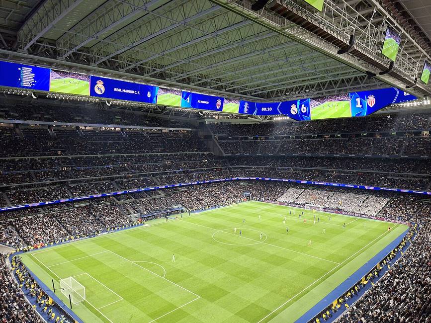 Vista interior de un estadio de fútbol durante un partido nocturno
