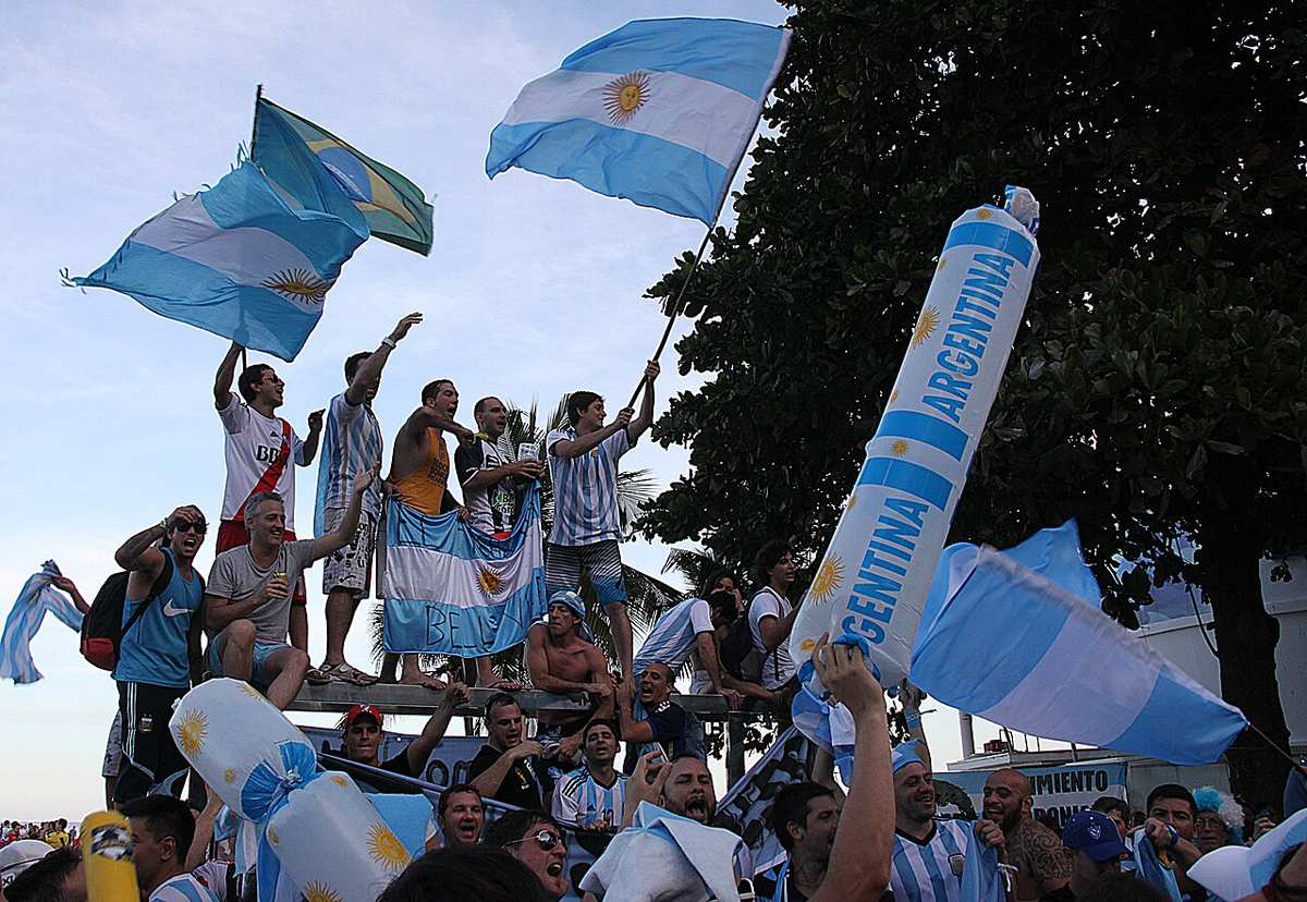 Aficionados argentinos celebrando con banderas en un Mundial
