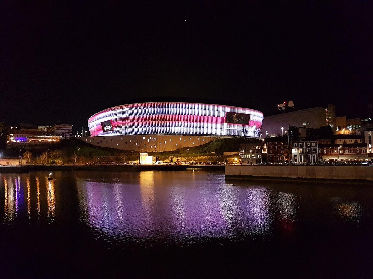 Fachada del estadio de San Mamés de noche, iluminada en Bilbao