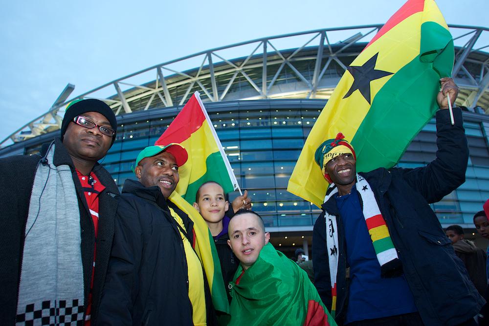 Aficionados de Ghana con banderas fuera de un estadio antes de un partido internacional