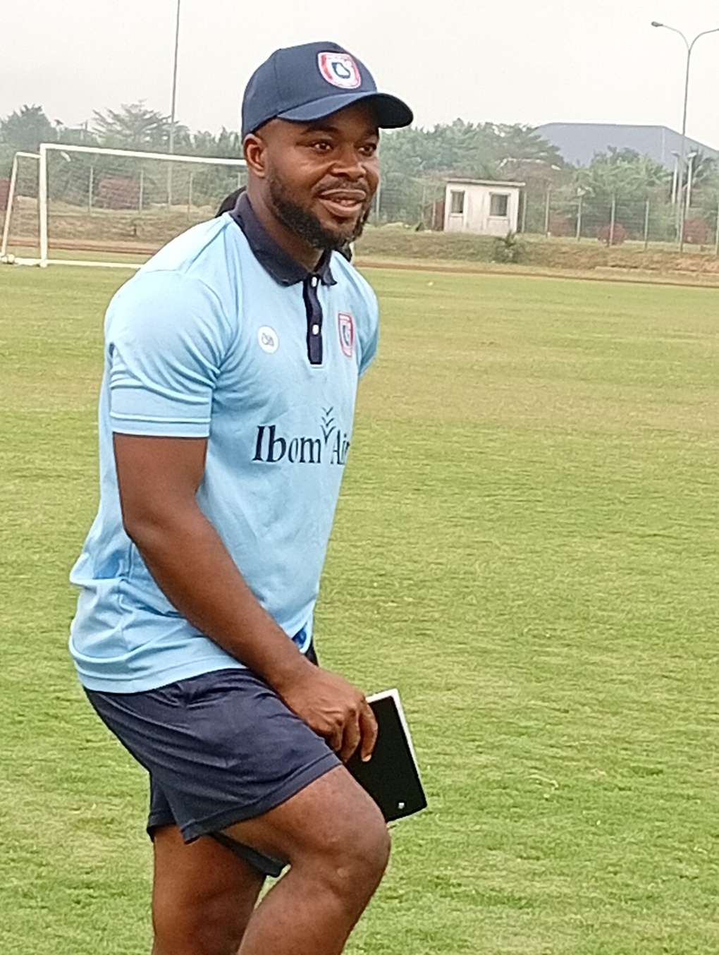 A soccer coach standing on the touchline during a match