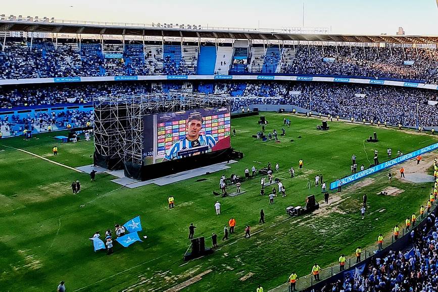 Jugadores disputando un partido sudamericano en un estadio lleno