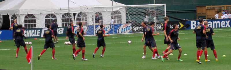 Players warming up on a football pitch before a match involving Jamaica