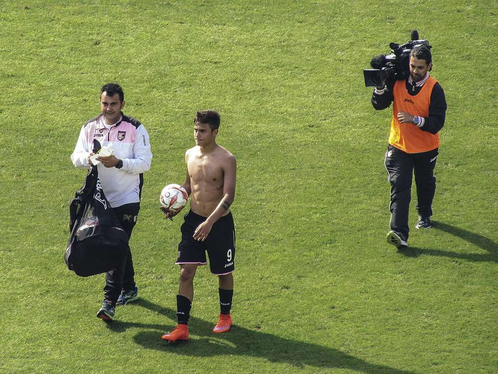 Un joven Paulo Dybala con el balón en la mano sobre el césped tras un partido