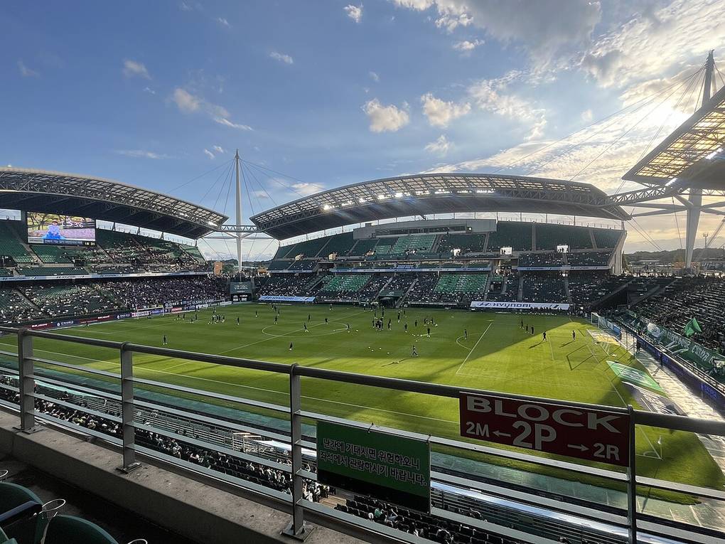 Interior de un estadio mundialista con el campo verde y las gradas durante un partido