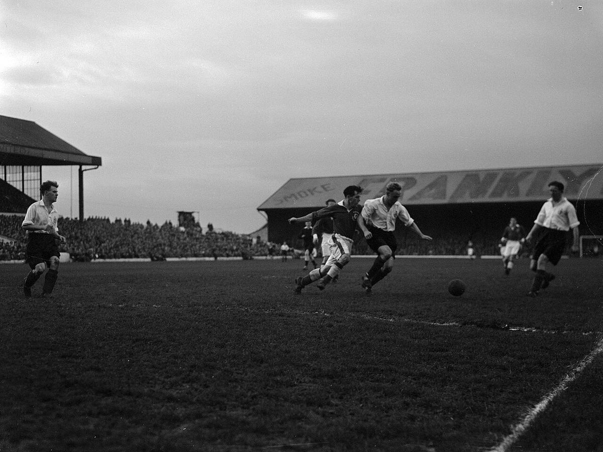 Partido de fútbol en un estadio de Cardiff con jugadores disputando el balón