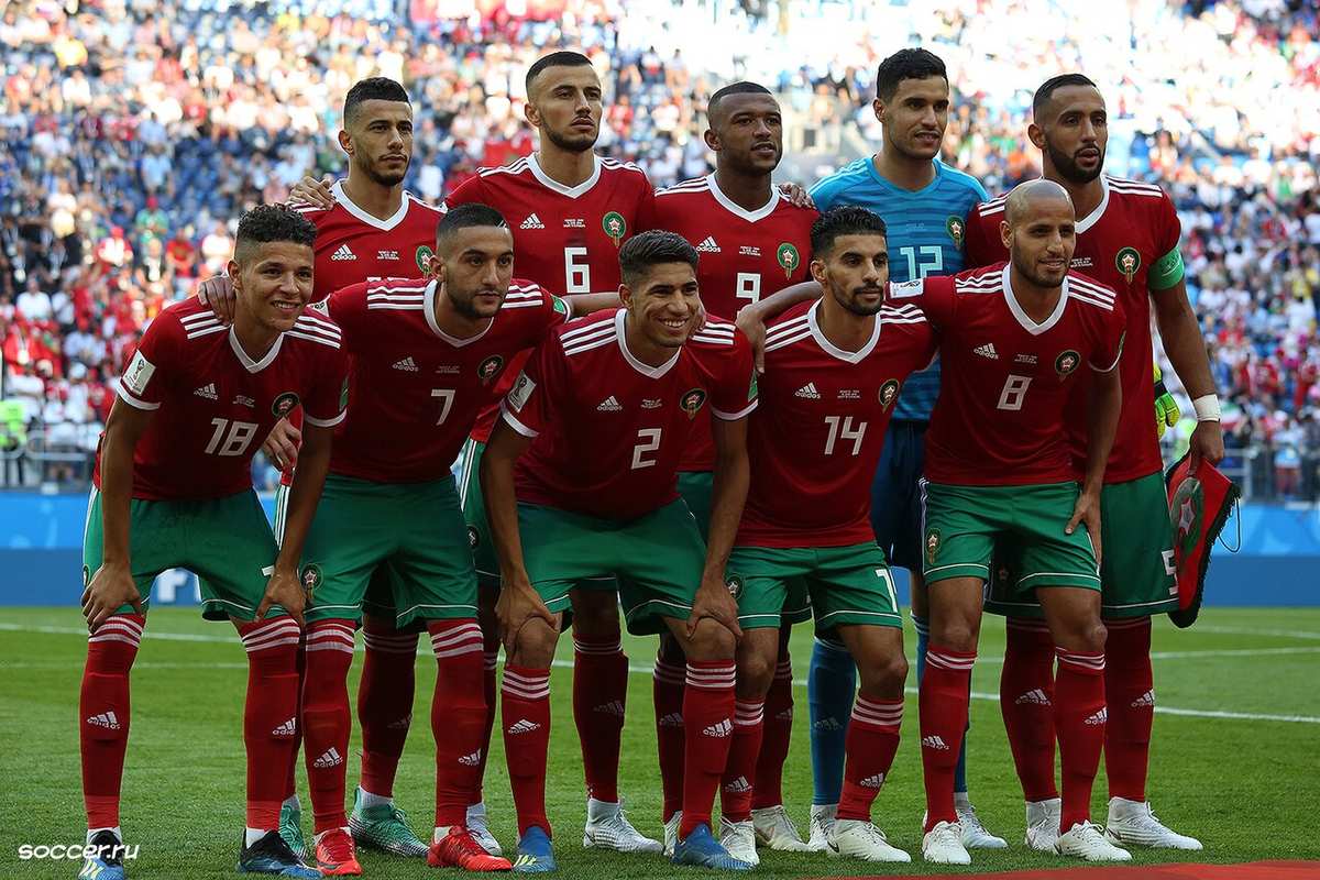 Joueurs du Maroc en action contre l'Iran lors d'un match international, en maillots rouges